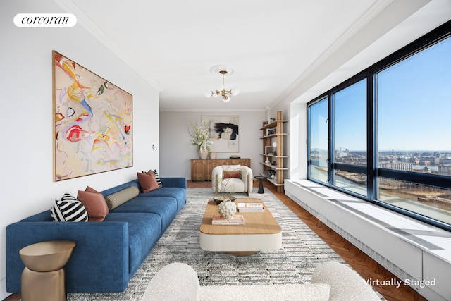 living area featuring crown molding, wood finished floors, a chandelier, and visible vents