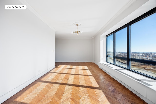 empty room with visible vents, a view of city, crown molding, baseboards, and a chandelier