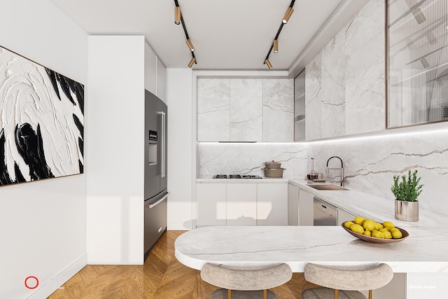 bathroom featuring decorative backsplash, rail lighting, and a sink