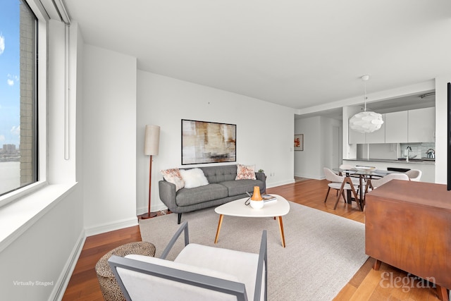 living area featuring baseboards and light wood-style floors