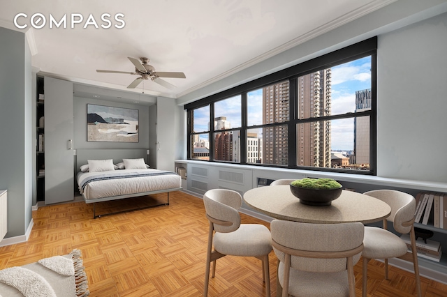 bedroom featuring a view of city, ornamental molding, and a ceiling fan