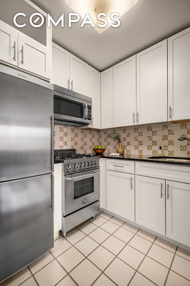 kitchen featuring backsplash, high end appliances, and white cabinets