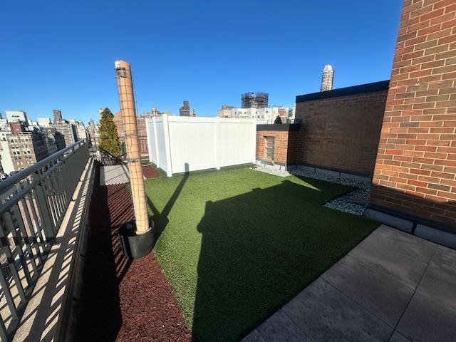 view of yard with a city view, a balcony, and fence