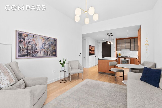 515 W 18th St Unit 403, New York City, NY 10011 - living area featuring light wood-style flooring, a chandelier, beverage cooler, baseboards, and recessed lighting