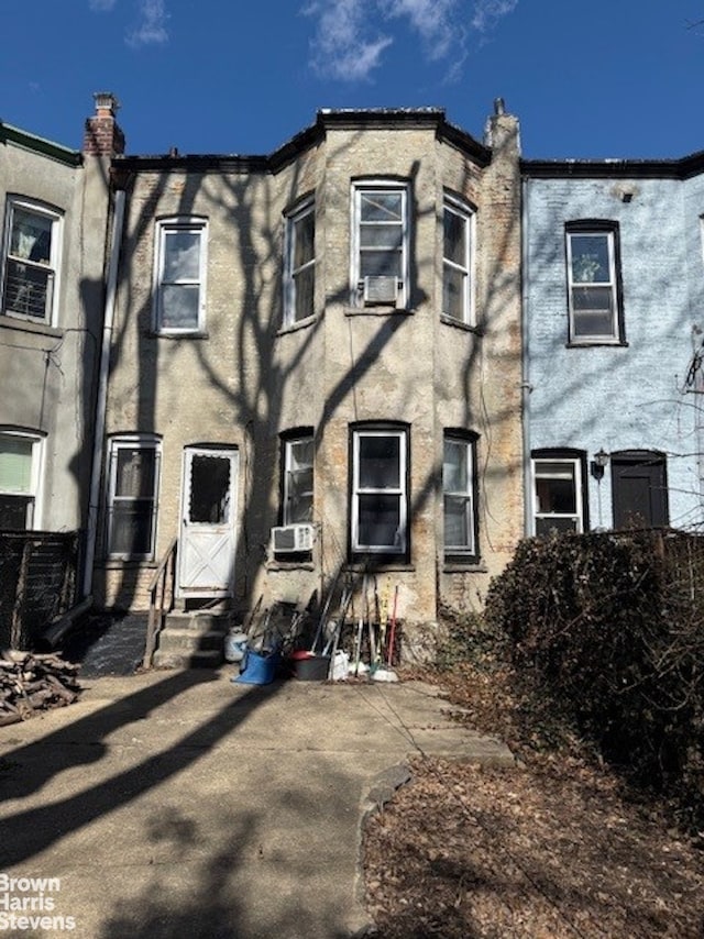 townhome / multi-family property with entry steps, cooling unit, and stucco siding