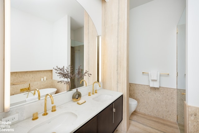 full bath featuring a sink, a wainscoted wall, toilet, and double vanity