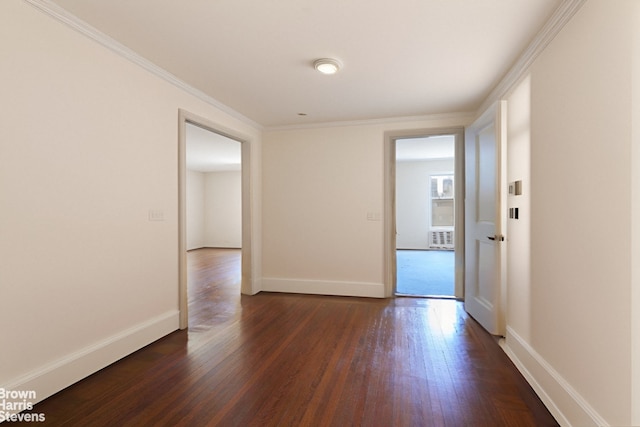 empty room featuring baseboards, ornamental molding, and dark wood-style flooring