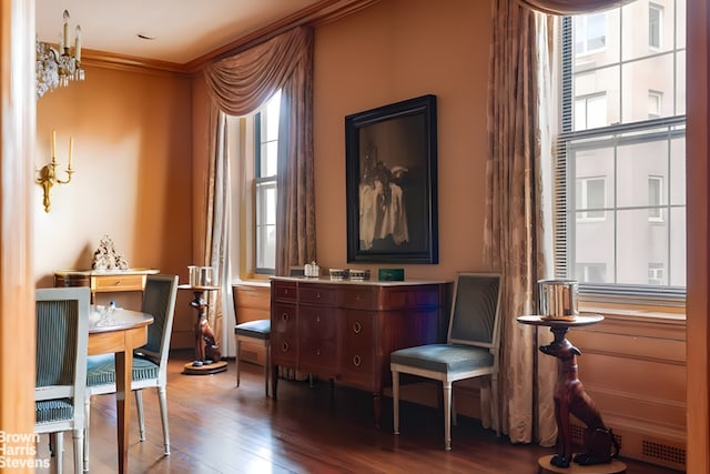 sitting room featuring ornamental molding and dark wood-style flooring