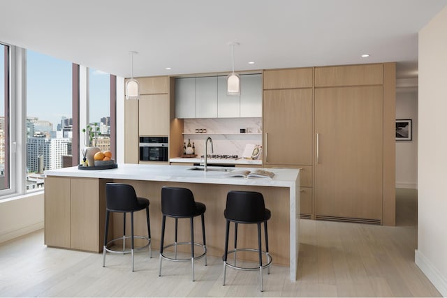 kitchen with a kitchen bar, modern cabinets, light countertops, and stainless steel oven