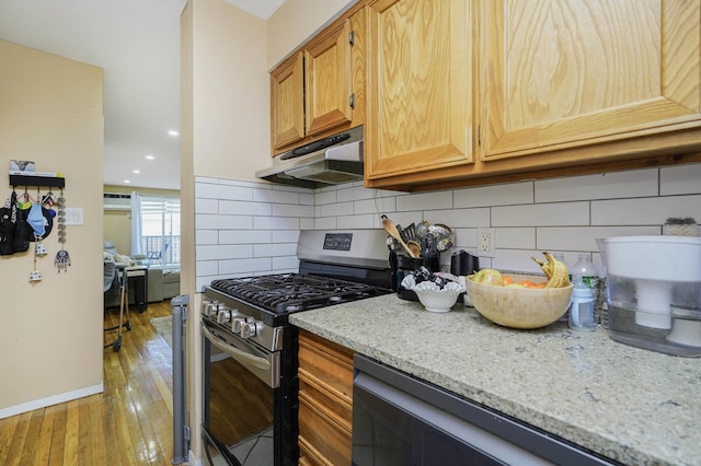 9729 4th Ave Unit 3-C, New York City, NY 11209 - kitchen featuring stainless steel gas range oven, under cabinet range hood, light wood-style flooring, decorative backsplash, and recessed lighting