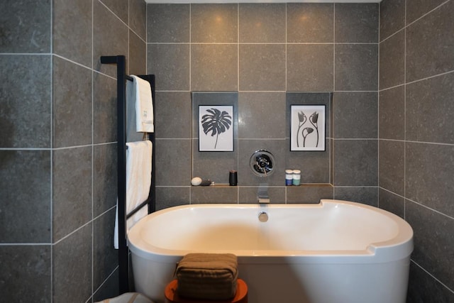 bathroom featuring tile walls and a freestanding tub