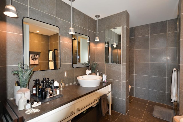 full bathroom featuring backsplash, a walk in shower, vanity, tile patterned floors, and tile walls