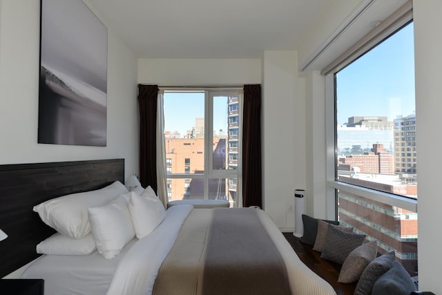 bedroom with a city view and multiple windows