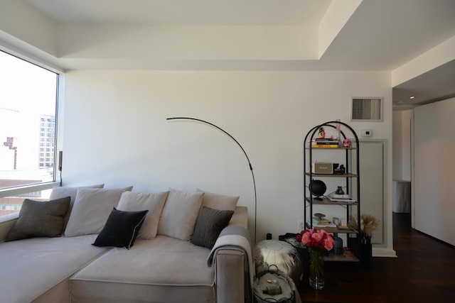 living area with wood finished floors, visible vents, and a wealth of natural light