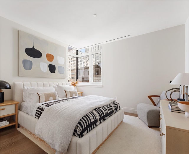 bedroom with baseboards and wood finished floors