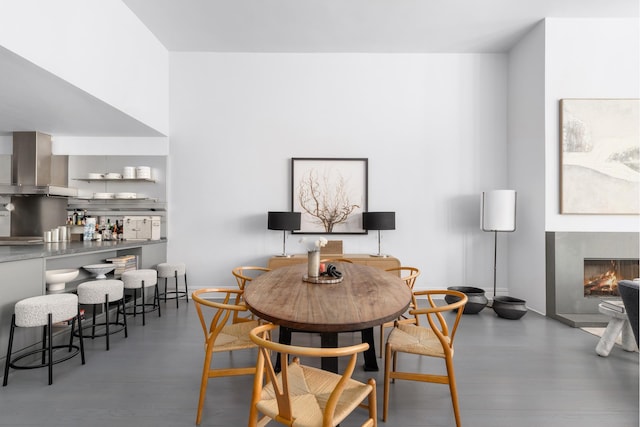 dining area featuring a lit fireplace and wood finished floors