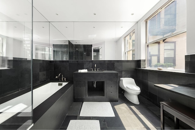 48 Mercer St Unit 6, New York City, NY 10013 - bathroom featuring tile walls, a garden tub, vanity, and tile patterned flooring