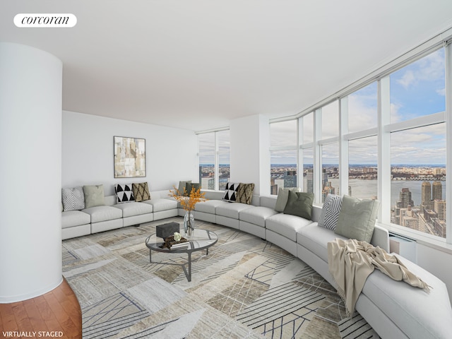 living area with visible vents, a water view, and wood finished floors