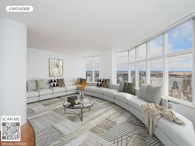 living area featuring a healthy amount of sunlight, a water view, wood finished floors, and visible vents