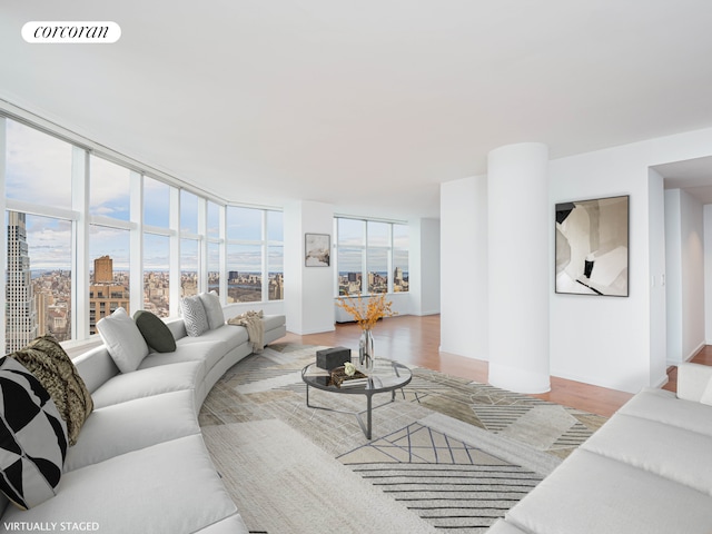 living room with visible vents, floor to ceiling windows, and light wood finished floors