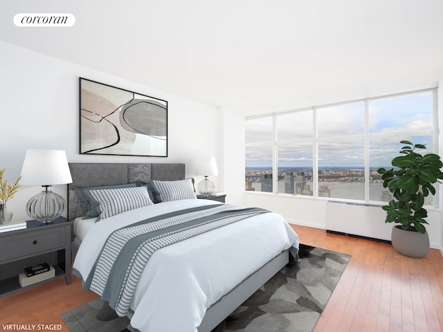 bedroom featuring a water view, visible vents, and wood finished floors
