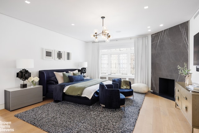 bedroom featuring recessed lighting, an inviting chandelier, and light wood-style floors