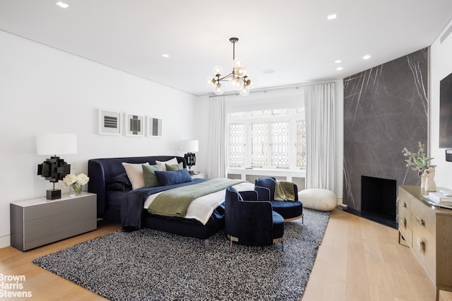 171 W 71st St Unit 9/10A, New York City, NY 10023 - bedroom featuring light wood-style floors, a chandelier, recessed lighting, and a fireplace