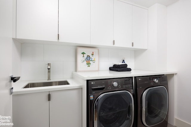 laundry area with washer and clothes dryer, cabinet space, and a sink