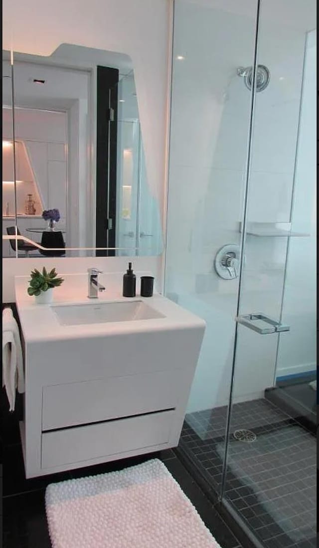 bathroom featuring tile patterned floors, a stall shower, and vanity