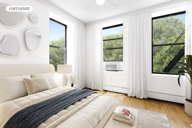 bedroom featuring light wood-style flooring, ceiling fan, and multiple windows