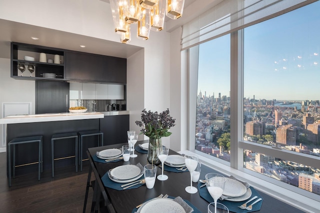 dining space with a notable chandelier, a view of city, and dark wood-type flooring