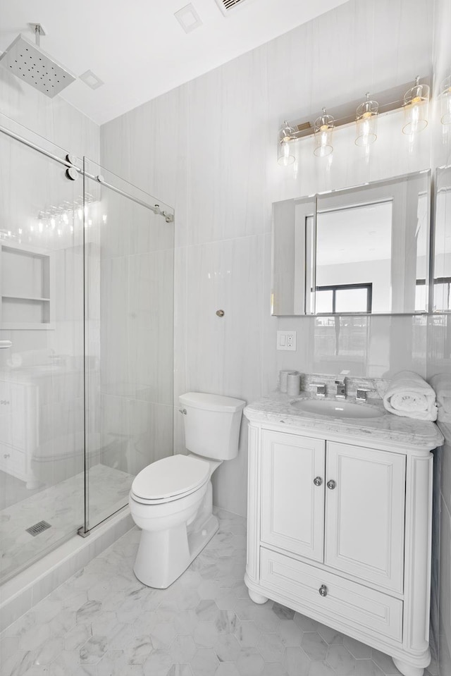 full bath with visible vents, toilet, marble finish floor, a stall shower, and vanity