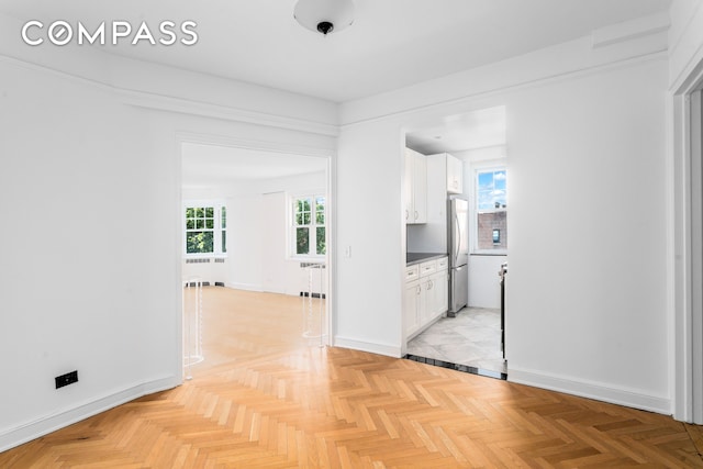 hallway with radiator heating unit and baseboards