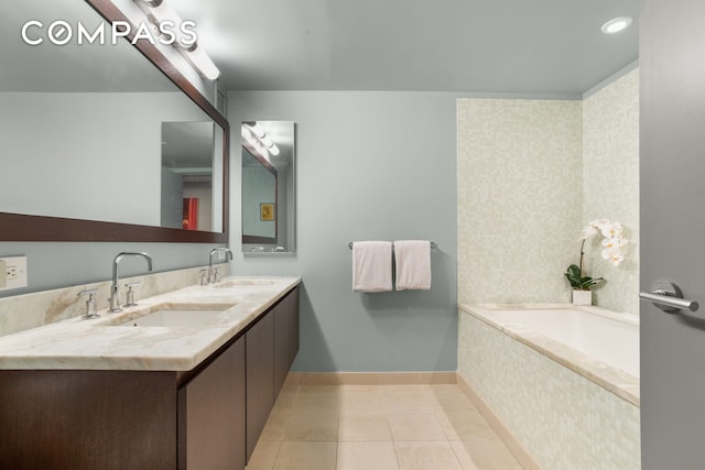 bathroom with tile patterned floors, a bath, double vanity, and baseboards