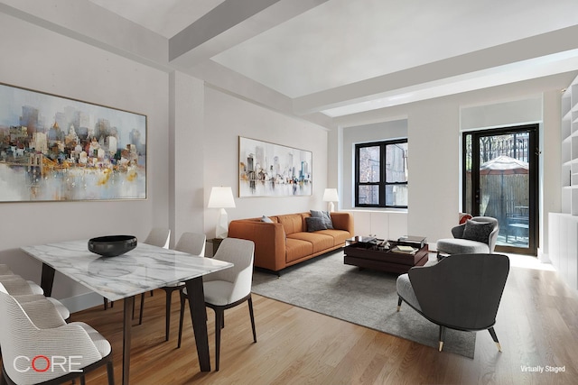 living area with light wood finished floors and beam ceiling