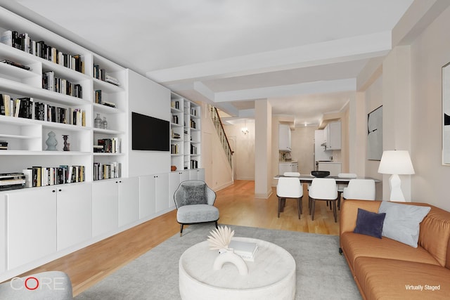 living area featuring light wood-style floors and stairs