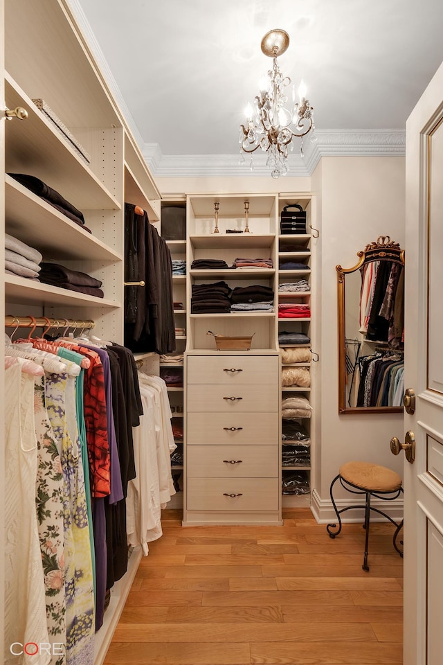 spacious closet with a notable chandelier and light wood finished floors