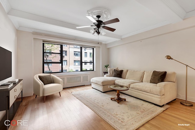 living room featuring beamed ceiling, crown molding, light wood-type flooring, and a ceiling fan