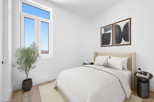 bedroom with wood finished floors and baseboards