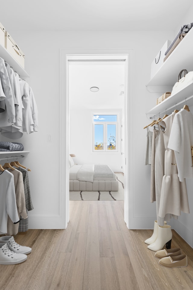 walk in closet with light wood-style floors