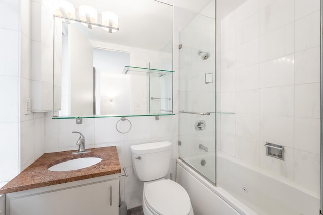 full bathroom featuring backsplash, bath / shower combo with glass door, toilet, vanity, and tile walls