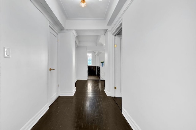 hall featuring baseboards and dark wood-style flooring