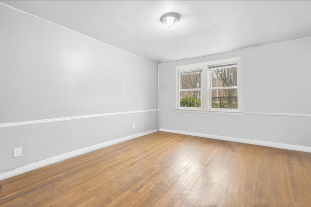 empty room with baseboards and hardwood / wood-style flooring