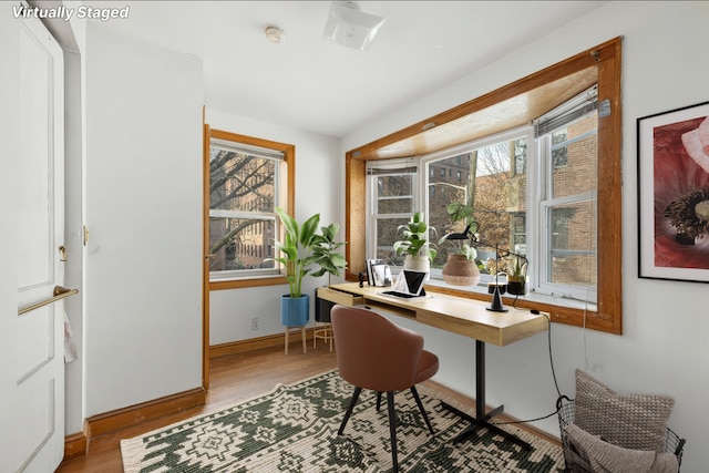 office with baseboards and light wood-style flooring