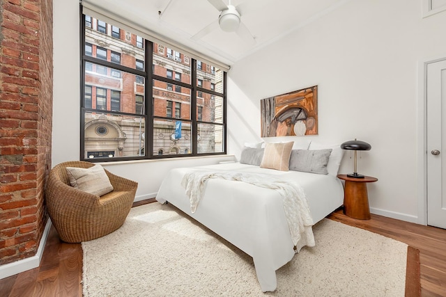 bedroom with baseboards, wood finished floors, and a ceiling fan