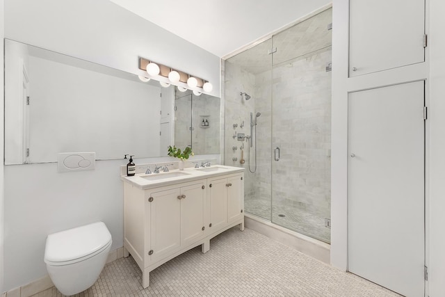 full bathroom featuring double vanity, toilet, a stall shower, and a sink