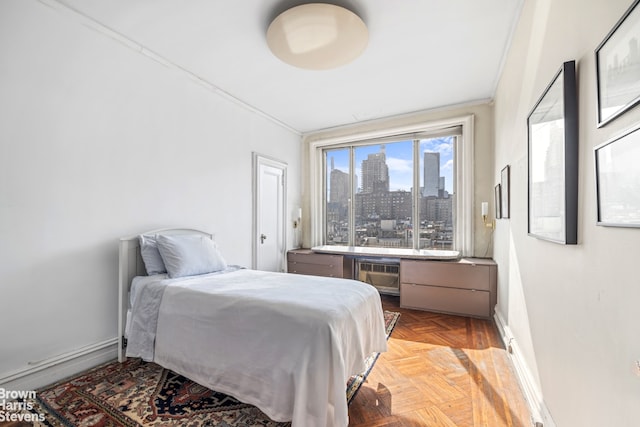 bedroom with baseboards, a view of city, and crown molding