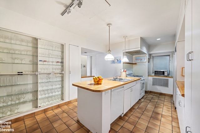 kitchen with wood counters, white appliances, tile patterned flooring, and white cabinetry