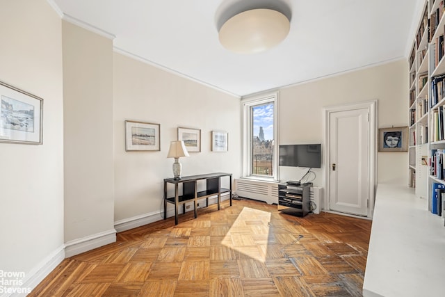 living area with baseboards and ornamental molding