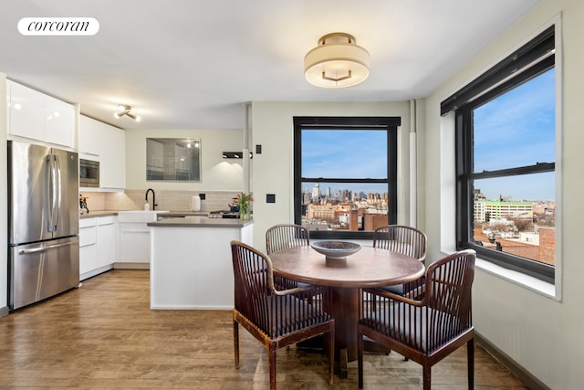 dining area with light wood-style floors, visible vents, and baseboards